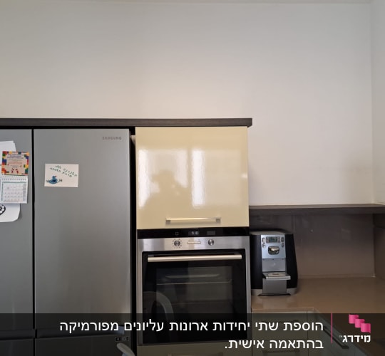 מטבח עם מקרר, תנור ומכונת קפה על השיש